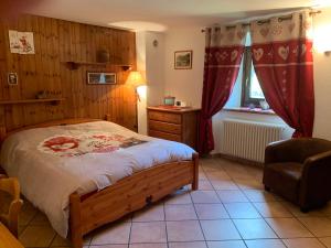 a bedroom with a bed and a chair and a window at Appartamenti da Clara in La Thuile