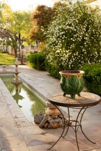 un vase assis sur une table à côté d'une fontaine dans l'établissement La Posada del Moro, à Cazalla de la Sierra