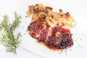um prato branco de alimentos com carne e molho de cranberry em La Posada del Moro em Cazalla de la Sierra