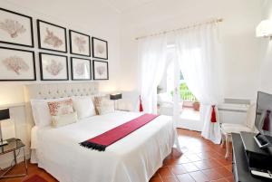 una camera con un letto bianco e una finestra di Carthusia Suites a Capri