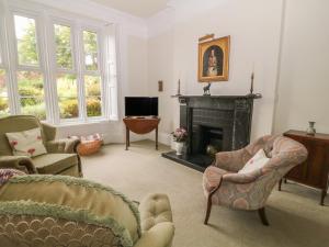 sala de estar con 2 sillas y chimenea en The Old Vicarage, en Tiverton