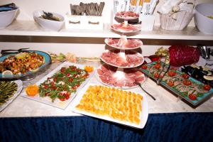 uma mesa com vários tipos diferentes de alimentos em Hotel Caraibi em Rimini