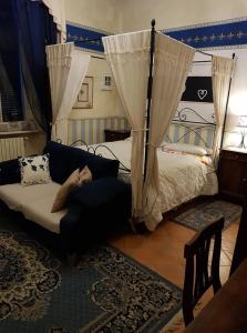 a bedroom with a bed and a couch and curtains at White Lady B&B in Monticelli dʼOngina