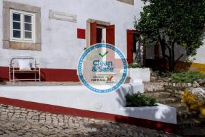 a sign for a clean and safe house at Lugares Com História in Óbidos