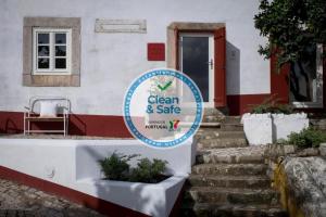 a sign for a clean and safe house at Lugares Com História in Óbidos