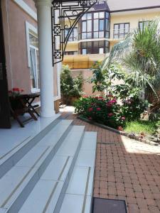 a courtyard of a building with a pillar and flowers at Guest House Assol in Loo