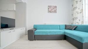 sala de estar con sofá azul y TV en Giorgia and Ary, en Brasov
