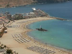 a beach with a large group of people on it at Los Cristianos Beach apartments in Los Cristianos