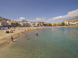 a group of people in the water at a beach at Los Cristianos Beach apartments in Los Cristianos