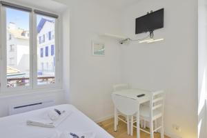 a room with a bed and a desk and a window at Studio Gaston - Welkeys in Biarritz