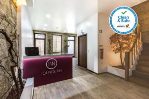 a lobby of a building with a welcome sign and stairs at Lounge Inn Guest House in Porto