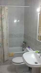 a bathroom with a white toilet and a sink at Los Cristianos Beach apartments in Los Cristianos