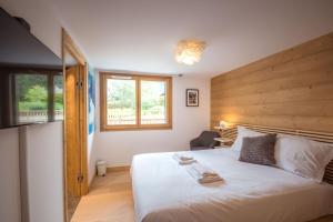 ein Schlafzimmer mit einem großen weißen Bett und einem Fenster in der Unterkunft Résidence Le Green in Chamonix-Mont-Blanc