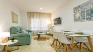 - un salon avec une table et un canapé vert dans l'établissement Apartamento El Califa - 1 Habitación, à Cordoue