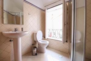 łazienka z toaletą, umywalką i oknem w obiekcie Dolce Vianna - City Centre Rooms w mieście Viana do Castelo