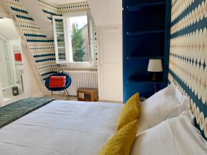 Schlafzimmer mit einem Bett mit blauem Kopfteil in der Unterkunft La Villégiature in Vichy