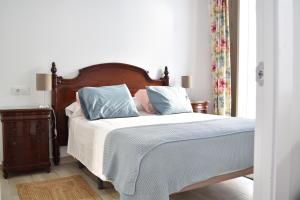 Schlafzimmer mit einem Bett mit blauen und rosa Kissen in der Unterkunft Apartamento La Discusión de Veedor 12 in Cádiz