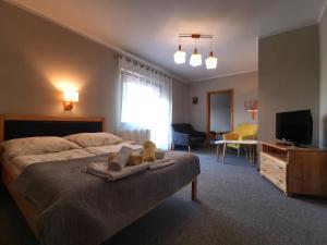 a bedroom with a bed with two stuffed animals on it at Galicówka in Poronin