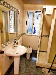 ein Badezimmer mit einem Waschbecken, einem WC und einem Spiegel in der Unterkunft AB Pension Granada in Granada