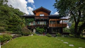 a large wooden house with a green yard at Alpenrelax Haus Weidmannsheil wohnen im romantischen Forsthaus in Werfen