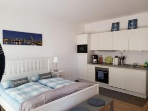 um quarto branco com uma cama e uma cozinha em Heimathaven 3 em Bremerhaven