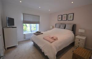 a bedroom with a large bed and a television at Jan Dee Cottage in Ventnor