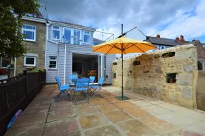 Jan Dee Cottage في فنتنور: فناء بطاولة ومظلة صفراء