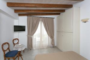 een eetkamer met een tafel en stoelen en een raam bij Aldarogi in Capri