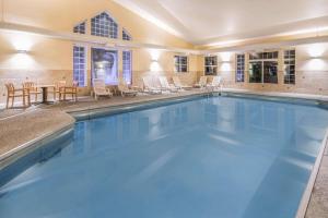 a large swimming pool with chairs and a table at La Quinta by Wyndham Belgrade - Bozeman Airport in Belgrade
