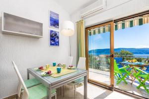 a dining room with a table and a balcony at Apartment Ladislav in Linardići