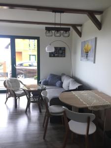 a living room with a couch and a table at Bajkowy domek in Lubin