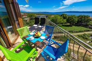 a table and chairs on a balcony with a view of the water at Apartment Ladislav in Linardići