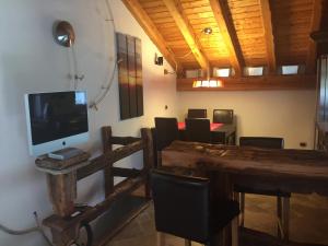 sala de estar con mesa, TV, mesa y sillas en CHALET GORRET CHENEIL, en Valtournenche