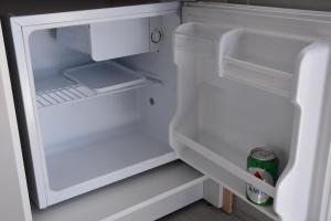 an open refrigerator with a can of soda in it at 4Bro Rooms Laerma Village in Láerma
