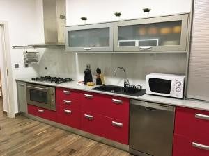 eine Küche mit roten Schränken und einer Mikrowelle in der Unterkunft Apartamento da Seara "Lamego" in Lamego