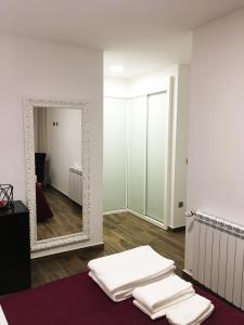 ein Zimmer mit einem Spiegel und einem Stapel Handtücher in der Unterkunft Apartamento da Seara "Lamego" in Lamego + 25 Fotos