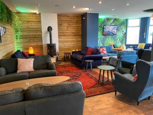a living room with couches and chairs and a fireplace at Oceanside Lifestyle Hotel in Newquay
