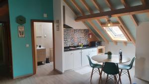 a kitchen with a table and chairs in a room at GO4SURF beach Lofts in Peniche