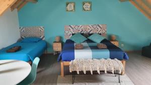 ペニシェにあるGO4SURF beach Loftsの青いベッドルーム(ベッド1台、テーブル付)