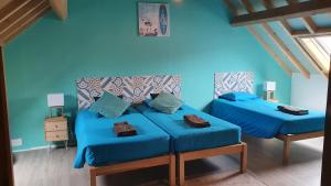 twee bedden in een kamer met blauwe muren bij GO4SURF beach Lofts in Peniche
