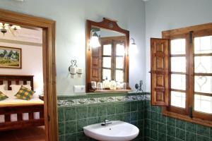 a bathroom with a sink and a mirror and a bed at Molino Cuatro Paradas in Benaoján +55 photos