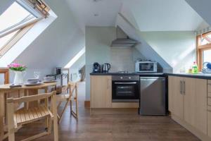 a kitchen with a stove and a table with chairs at The Chalet Somerset in Angersleigh