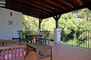 a patio with tables and chairs and a fence at Molino Cuatro Paradas in Benaoján