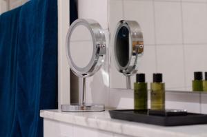 uma casa de banho com dois espelhos e uma cortina azul em Hotel am Feldmarksee em Sassenberg