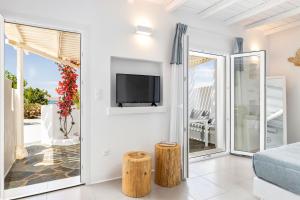 een woonkamer met een tv aan de muur bij Blue Mare Villas in Naousa