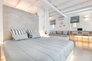 um quarto com uma cama grande e um sofá em Blue Mare Villas em Naousa