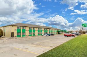 a building with cars parked in a parking lot at Cheyenne Guest Inn in Cheyenne