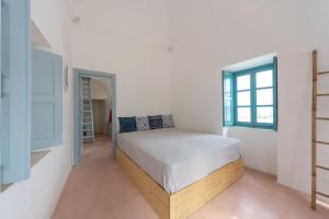 una camera da letto con un letto e una finestra di Santorinio Yellow House a Éxo Goniá