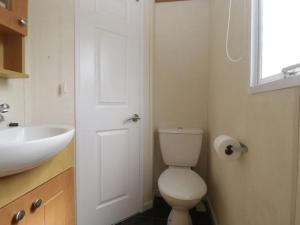 a bathroom with a white toilet and a sink at The Nest - Family friendly caravan nr Glastonbury & Street in Somerton