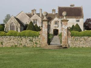 an old house with a stone wall and a gate at The Nest - Family friendly caravan nr Glastonbury & Street in Somerton